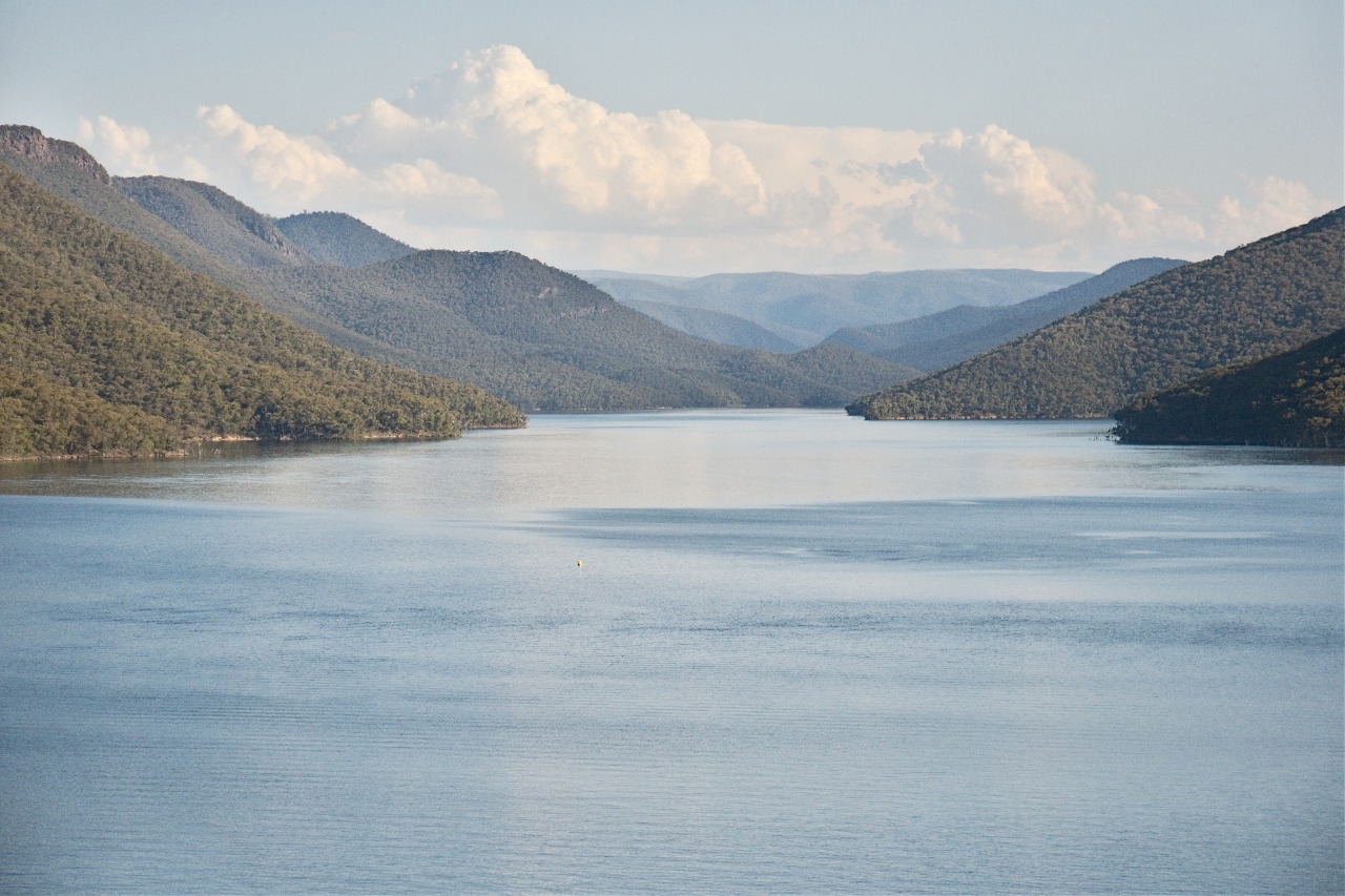 Talbingo Reservoir in summer with cumulus clouds building in the background.
