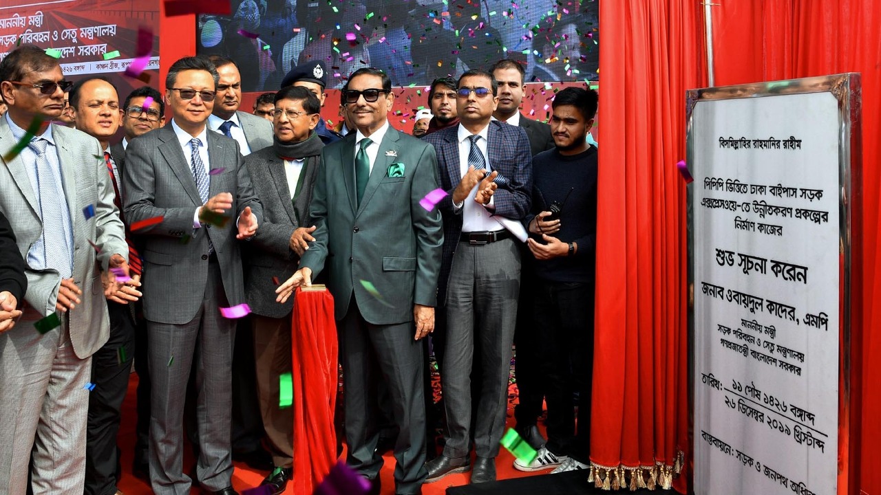 On Thursday, December 26, 2019, the Minister of Road Transport and Bridges, Obaidul Quader, inaugurated the construction work of the Dhaka Bypass Road Expressway Upgradation Project in Rupganj, Narayanganj. The English description and title of this file were generated using a large language model (Google Gemini - gemini-3.1-flash-lite) from the original Bengali description provided by the Press Information Department. Show prompts used: Translation prompt: Translate the following Bengali text in
