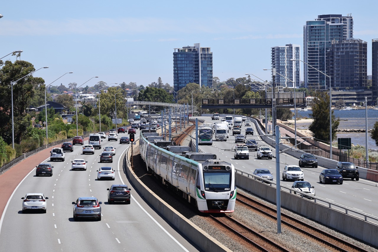 View of the Kwinana Freeway and the Mandurah line from the Thelma Street footbridge in Como, Western Australia, photographed in November 2025. A B-series train is visible.