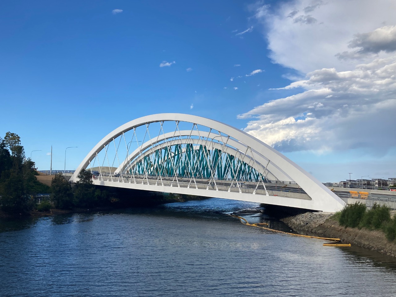 The Twin Arch Bridges as part of the Sydney Gateway project, viewed from the shared path bridge across Alexandra Canal. The eastbound bridge has been completed and open to traffic. The westbound bridge at the back is still under construction.