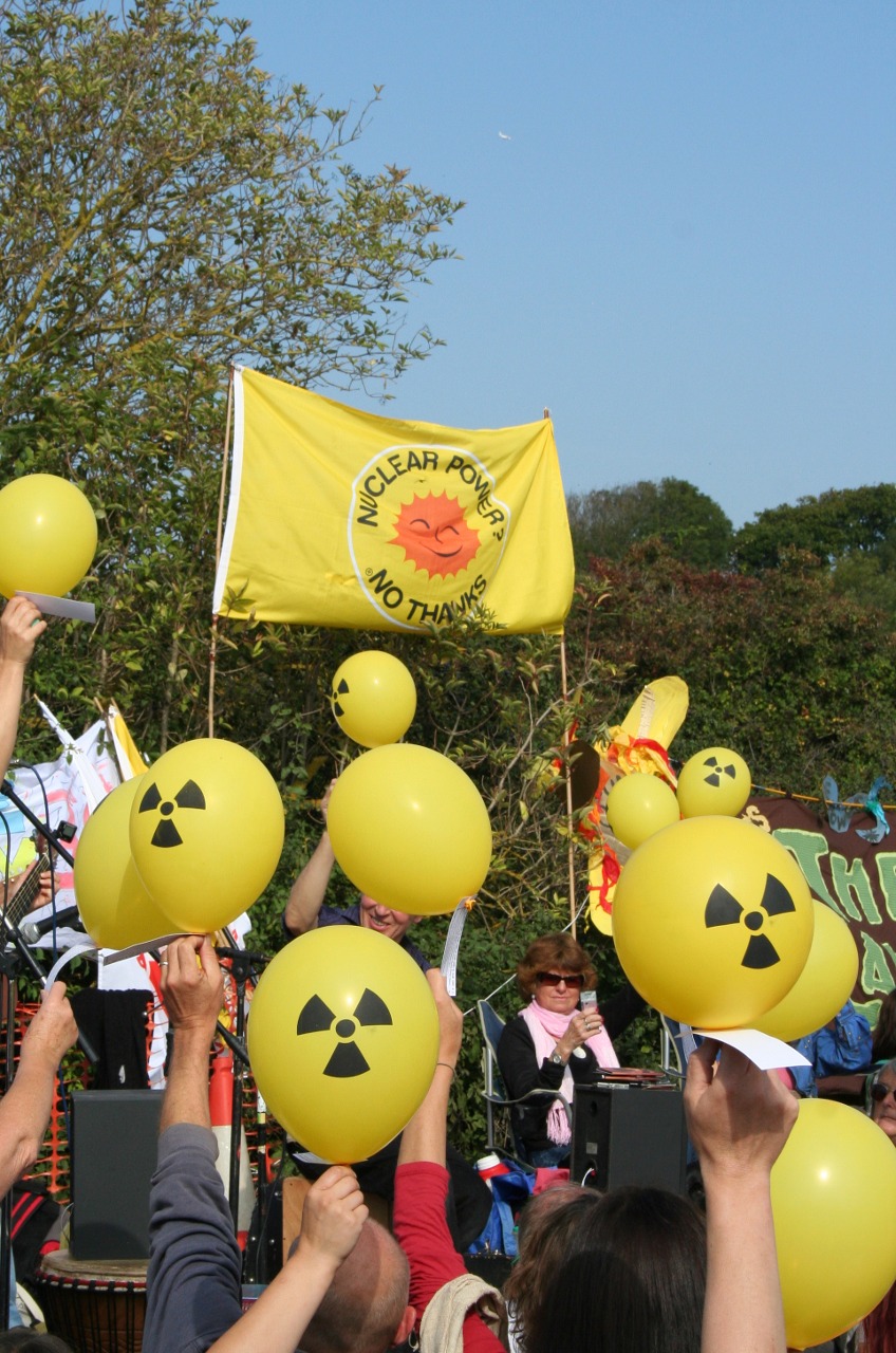 People with banners and balloons protesting against nuclear power at Hinkley Point Nuclear Power Station in Somerset, England