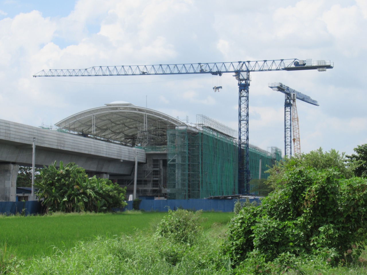 Construction of Balagtas station in 2022 along P. Atienza Street, Longos, Balagtas boundary - Sitio Karuyan, Longos - boundary Santa Cruz Subdivision Burol 1, Balagtas (where the New Balagtas Station is 90% finished); featuring also is the Old pre-WWII NIA irrigation structures canals along the alley and the Ipomoea aquatica plantations in the Philippines - paddy fields)