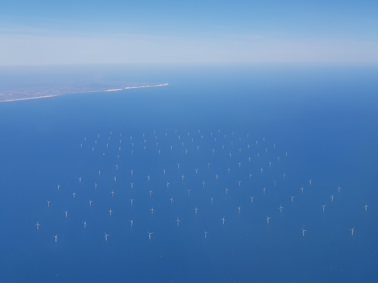 This is a photo of the Rampion offshore wind farm, off the coast of East Sussex on a calm day, taken from a plane